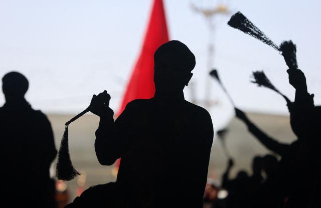 Shia Muslim devotees attend a mourning ritual in Iraq's holy city of Karbala on June 25, 2026, at the peak of Ashura, a 10-day period commemorating the seventh century killing of Prophet Mohammed's grandson Imam Hussein. (Photo by AHMAD AL-RUBAYE / AFP)