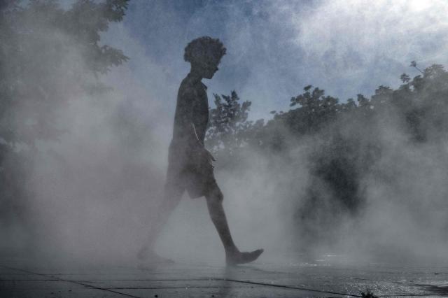 A child walks through a water fountain in Nice, southern France, on June 25, 2026. (Photo by Valery HACHE / AFP)