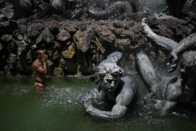 (FILES) A man cools off in the basin of the Girondins Fountain at Place des Quinconces as France experiences a heatwave, in Bordeaux, south-western France, on June 22, 2026. (Photo by Philippe LOPEZ / AFP)