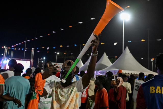 An Ivory Coast's National Football team supporter blows in a vuvuzela as he watches the 2026 FIFA World Cup football tournament match between Ivory Coast and Curacao at the Place de la Mairie in Abobo, suburb of Abidjan on June 25, 2026. (Photo by Issouf SANOGO / AFP)