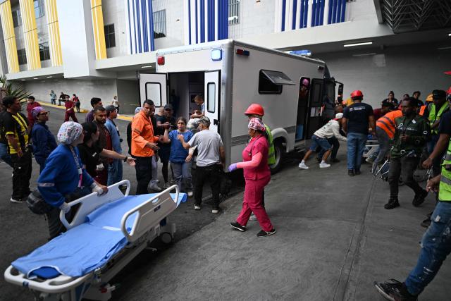 Rescuers and paramedics help a victim of the twin earthquake while being admitted at the Domingo Luciani hospital in Caracas, on June 25, 2026. The death toll from twin quakes, measured at magnitudes 7.2 and 7.5, has risen to at least 188, with more than 1,520 others injured, top lawmaker Jorge Rodriguez reported, while residents continue searching for missing relatives. (Photo by Juan BARRETO / AFP)