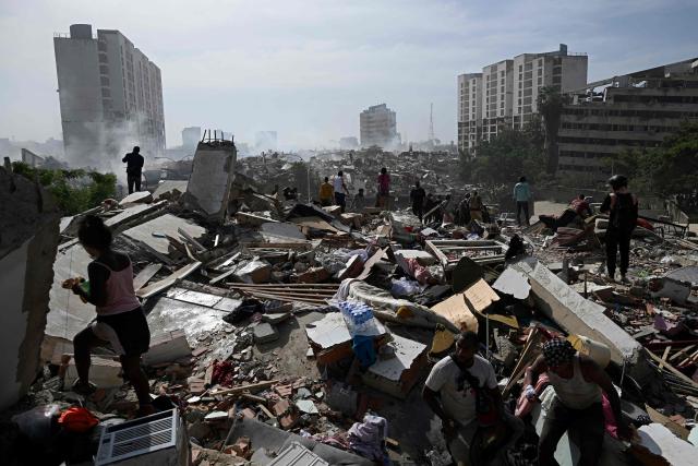 Locals walk amid rubble following a twin earthquake in Caraballeda, La Guaira state, about 40 km northeast of Caracas, on June 25, 2026. The death toll from twin quakes, measured at magnitudes 7.2 and 7.5, has risen to at least 188, with more than 1,520 others injured, top lawmaker Jorge Rodriguez reported, while residents continue searching for missing relatives. (Photo by Federico PARRA / AFP)