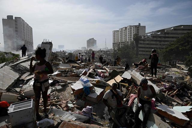 Locals walk amid rubble following a twin earthquake in Caraballeda, La Guaira state, about 40 km northeast of Caracas, on June 25, 2026. The death toll from twin quakes, measured at magnitudes 7.2 and 7.5, has risen to at least 188, with more than 1,520 others injured, top lawmaker Jorge Rodriguez reported, while residents continue searching for missing relatives. (Photo by Federico PARRA / AFP)