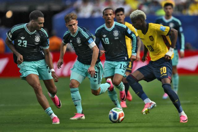 Germany's defender #23 Felix Nmecha, Germany's defender #06 Joshua Kimmich and Ecuador's forward #20 Nilson Angulo fight for the ball during the 2026 World Cup Group E football match between Ecuador and Germany at the New York/New Jersey Stadium in East Rutherford on June 25, 2026. (Photo by MAURO PIMENTEL / AFP)