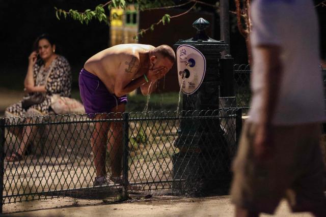 A man cools down a a public drinking fountain along the Canal Saint-Martin as France experiences a heatwave, in Paris on June 25, 2026. Due to the ongoing heatwave sweeping across France - the Bassin des Recollets - a portion of the Canal Saint-Martin in the French capital has been opened for swimming from June 17. Authorities said hospitals in Paris and its surrounding region were "saturated" and decided to ban alcohol consumption in the streets and public spaces from June 26 at noon, as well as alcohol sales from 6:00 pm. (Photo by Ludovic MARIN / AFP)