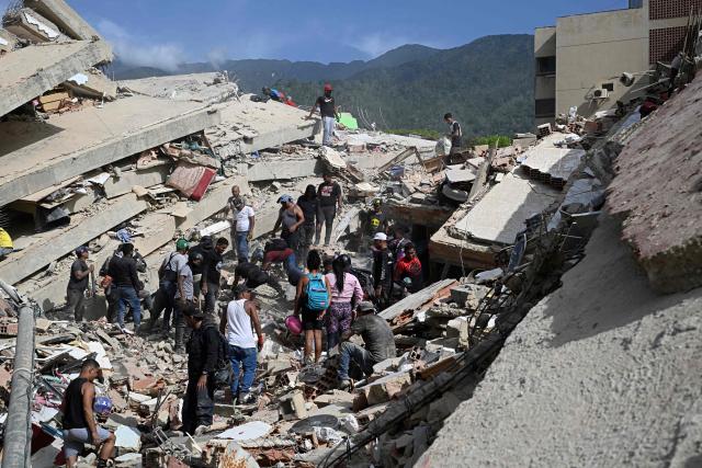 Volunteers look for possible victims amid the rubble following a twin earthquake in Caraballeda, La Guaira state, about 40 km northeast of Caracas, on June 25, 2026. The death toll from twin quakes, measured at magnitudes 7.2 and 7.5, has risen to at least 188, with more than 1,520 others injured, top lawmaker Jorge Rodriguez reported, while residents continue searching for missing relatives. (Photo by Federico PARRA / AFP)