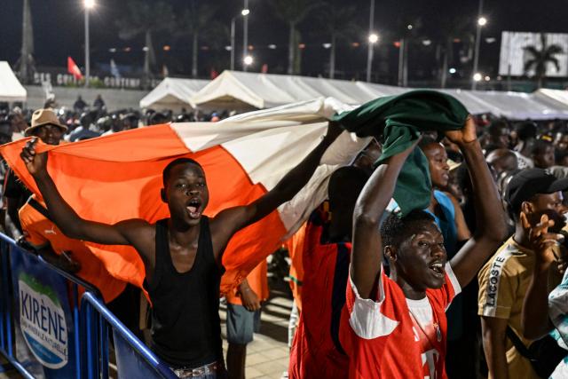 Ivory Coast's National Football team fans celebrate in front of a giant public brodcast screen as they watch the 2026 FIFA World Cup football tournament match between Ivory Coast and Curacao at the Place de la Mairie in Abobo, suburb of Abidjan on June 25, 2026. (Photo by Issouf SANOGO / AFP)