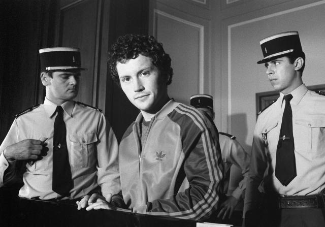 (FILES) Philippe Maurice (C), aged 26, appears for the third time before the Paris Assize Court in  Paris on June 28, 1982, charged with the murder of a security guard committed on July 27, 1979. From bank robberies to the hushed corridors of the National Archives: Philippe Maurice, Frances last person sentenced to death, who was spared the guillotine by a presidential pardon granted by François Mitterrand in May 1981, threw himself wholeheartedly into his studies before becoming a renowned medieval historian. (Photo by JOEL ROBINE / AFP)