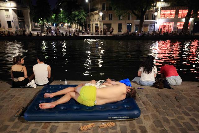 A youth cools down along the Canal Saint-Martin as France experiences a heatwave, in Paris on June 25, 2026. Due to the ongoing heatwave sweeping across France - the Bassin des Recollets - a portion of the Canal Saint-Martin in the French capital has been opened for swimming from June 17. (Photo by Ludovic MARIN / AFP)