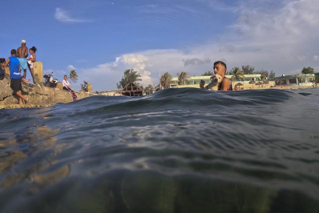 Young people swim off the coast of the Miramar neighborhood in Havana on June 24, 2026. (Photo by Pablo PORCIUNCULA / AFP)