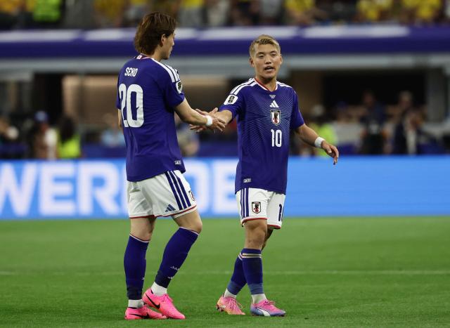 Japan's defender #20 Ayumu Seko and Japan's midfielder #10 Ritsu Doan shake hands during the 2026 World Cup Group F football match between Japan and Sweden at the Dallas Stadium in Arlington on June 25, 2026.  (Photo by Aric Becker / AFP)