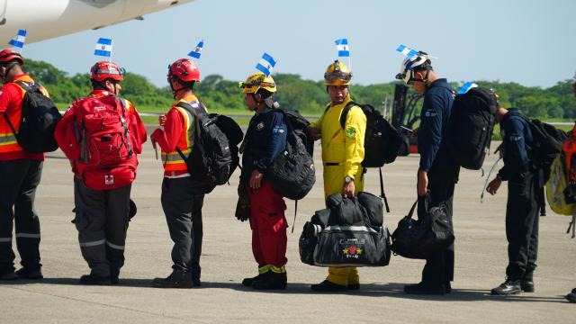 Salvadorean rescuers queue to board a plane heading to Venezuela, at Comalapa Air Base in San Luis Talpa, El Salvador, on June 25, 2026. A first plane carrying a 300-member team of rescuers and experts, as well as food supplies, was sent to Venezuela to assist after the devastating June 24 twin earthquakes. (Photo by Rudy QUIROZ / AFP)