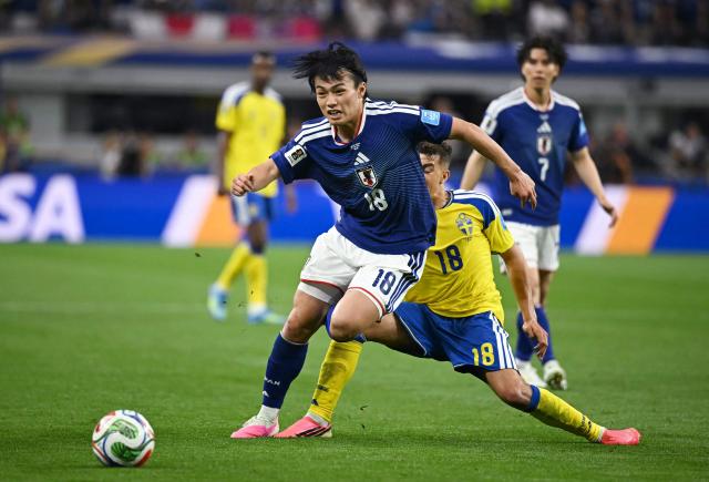 Japan's forward #18 Ayase Ueda and Sweden's midfielder #18 Yasin Ayari fight for the ball during the 2026 World Cup Group F football match between Japan and Sweden at the Dallas Stadium in Arlington on June 25, 2026.  (Photo by Paul ELLIS / AFP)