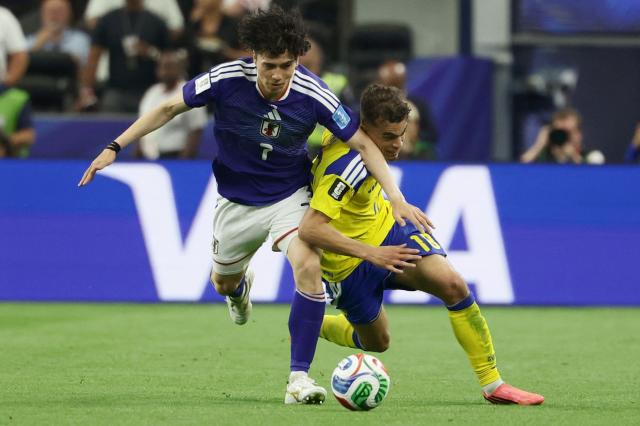 Japan's midfielder #07 Ao Tanaka and Sweden's midfielder #18 Yasin Ayari fight for the ball during the 2026 World Cup Group F football match between Japan and Sweden at the Dallas Stadium in Arlington on June 25, 2026.  (Photo by Aric Becker / AFP)
