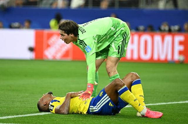 Sweden's goalkeeper #01 Jacob Widell Zetterstrom conforts teammate defender #04 Isak Hien as he reacts in pain during the 2026 World Cup Group F football match between Japan and Sweden at the Dallas Stadium in Arlington on June 25, 2026.  (Photo by Paul ELLIS / AFP)