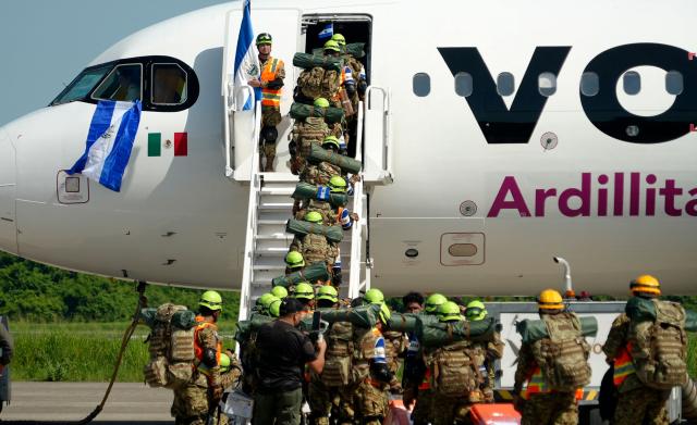 Salvadorean military members board a plane heading to Venezuela, at Comalapa Air Base in San Luis Talpa, El Salvador, on June 25, 2026. A first plane carrying a 300-member team of rescuers and experts, as well as food supplies, was sent to Venezuela to assist after the devastating June 24 twin earthquakes. (Photo by Rudy QUIROZ / AFP)