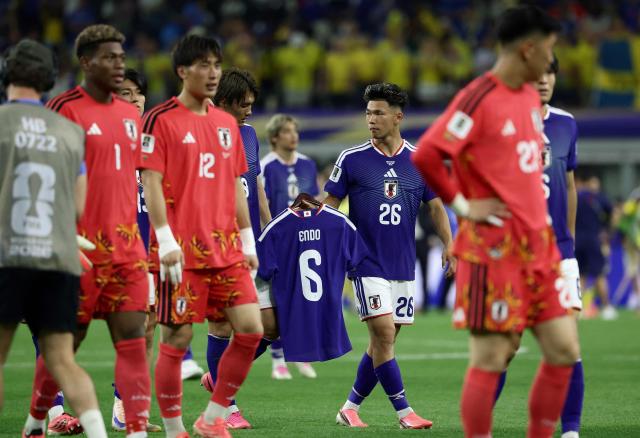 Japan's forward #26 Kento Shiogai shows a jersey of Japan's forward #06 Shuto Machino at the end of the 2026 World Cup Group F football match between Japan and Sweden at the Dallas Stadium in Arlington on June 25, 2026.  (Photo by Aric Becker / AFP)