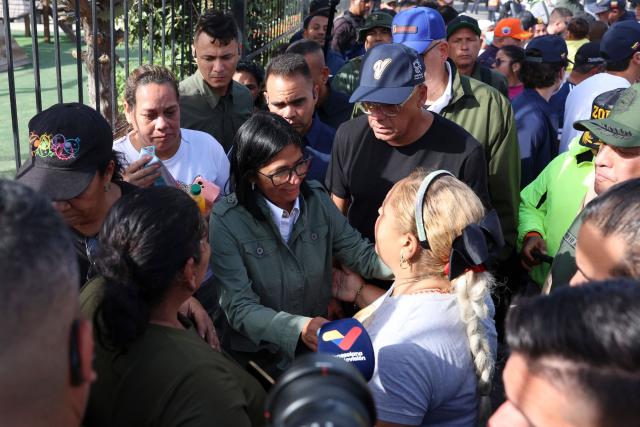Handout picture released by the Venezuelan presidency press office showing Venezuela's interim President Delcy Rodriguez (C) and Venezuela's National Assembly President Jorge Rodriguez speaking with residents in the area strongly affected by the earthquake in La Guaira, on June 25, 2026. Desperate Venezuelans raced to find and rescue loved ones trapped alive beneath the rubble of collapsed buildings after two major earthquakes --measured at magnitudes 7.2 and 7.5-- hit northern Venezuela killing at least 235 people and leaving more than 1,500 injured. (Photo by Handout / Venezuelan Presidency / AFP)