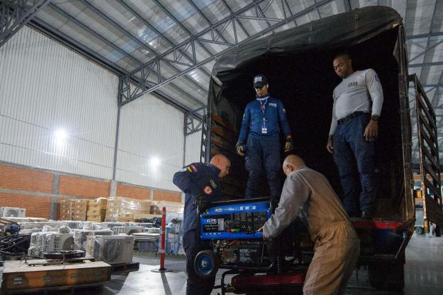 Colombian firefighters prepare equipment before departing with humanitarian aid to Venezuela at Catam Air Base in Bogota on June 25, 2026, following deadly earthquakes. Desperate Venezuelans raced to find and rescue loved ones trapped alive beneath the rubble of collapsed buildings after two major earthquakes, measured at magnitudes 7.2 and 7.5, hit northern Venezuela killing at least 235 people and leaving more than 1,500 injured. (Photo by Sebastian BARROS / AFP)