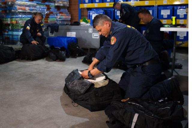 Colombian firefighters prepare equipment before departing with humanitarian aid to Venezuela at Catam Air Base in Bogota on June 25, 2026, following deadly earthquakes. Desperate Venezuelans raced to find and rescue loved ones trapped alive beneath the rubble of collapsed buildings after two major earthquakes, measured at magnitudes 7.2 and 7.5, hit northern Venezuela killing at least 235 people and leaving more than 1,500 injured. (Photo by Sebastian BARROS / AFP)