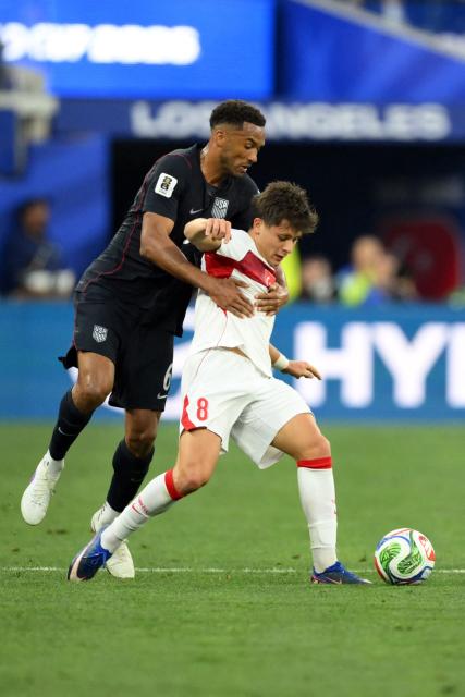 Turkey's midfielder #08 Arda Guler and US defender #06 Auston Trusty fight for the ball during the 2026 World Cup Group D football match between Turkey and USA at the Los Angeles Stadium in Inglewood on June 25, 2026.  (Photo by Patrick T. FALLON / AFP)