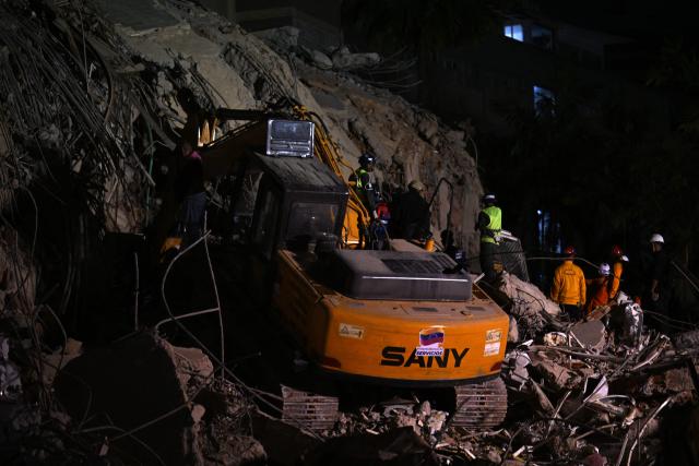 Rescue teams operate heavy machinery at the site of a collapsed building in Caracas on June 25, 2026, following earthquakes. Desperate Venezuelans raced to find and rescue loved ones trapped alive beneath the rubble of collapsed buildings after two major earthquakes, measured at magnitudes 7.2 and 7.5, hit northern Venezuela killing at least 235 people and leaving more than 1,500 injured. (Photo by Juan BARRETO / AFP)