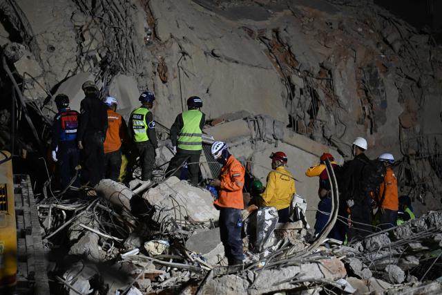 Rescue workers search through the rubble of a collapsed building in Caracas on June 25, 2026, following earthquakes. Desperate Venezuelans raced to find and rescue loved ones trapped alive beneath the rubble of collapsed buildings after two major earthquakes, measured at magnitudes 7.2 and 7.5, hit northern Venezuela killing at least 235 people and leaving more than 1,500 injured. (Photo by Juan BARRETO / AFP)