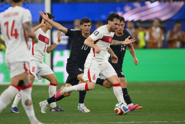 US forward #10 Christian Pulisic and Turkey's midfielder #06 Orkun Kokcu fight for the ball during the 2026 World Cup Group D football match between Turkey and USA at the Los Angeles Stadium in Inglewood on June 25, 2026.  (Photo by Patrick T. FALLON / AFP)