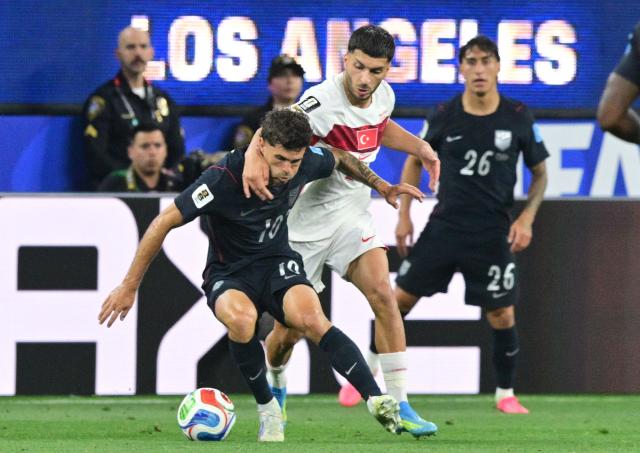 US forward #10 Christian Pulisic and Turkey's forward #24 Oguz Aydin fight for the ball during the 2026 World Cup Group D football match between Turkey and USA at the Los Angeles Stadium in Inglewood on June 25, 2026.  (Photo by Frederic J. BROWN / AFP)