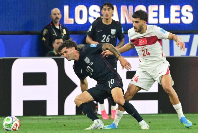 US forward #10 Christian Pulisic and Turkey's forward #24 Oguz Aydin fight for the ball during the 2026 World Cup Group D football match between Turkey and USA at the Los Angeles Stadium in Inglewood on June 25, 2026.  (Photo by Frederic J. BROWN / AFP)