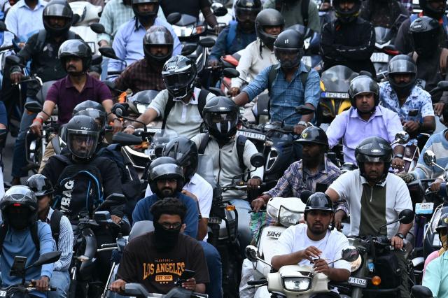 Commuters wait in a traffic jam along a road in Bengaluru on June 26, 2026. (Photo by Idrees MOHAMMED / AFP)