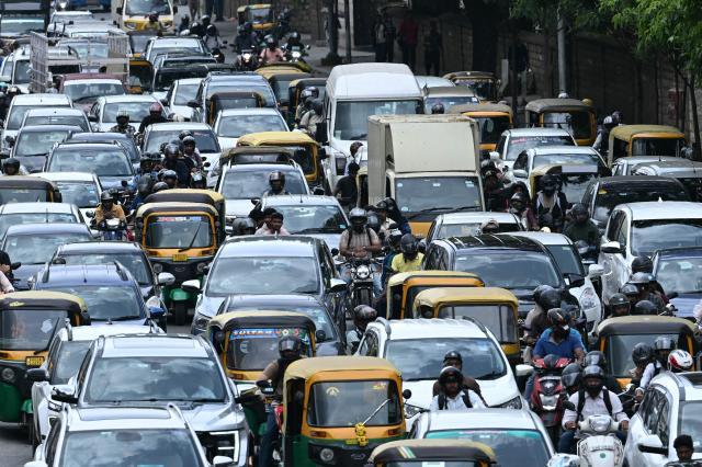Commuters wait in a traffic jam along a road in Bengaluru on June 26, 2026. (Photo by Idrees MOHAMMED / AFP)