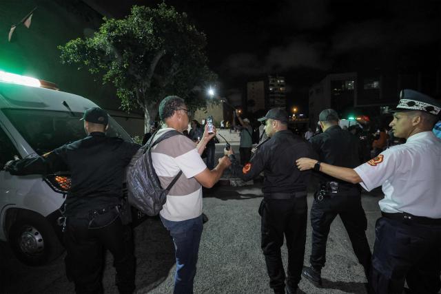 Policemen clear the area as Said Naciri and Abdennabi Bioui, two Moroccan public figures sentenced to 10 and 12 years in prison over a major drug trafficking scheme linked to a convicted Malian kingpin, dubbed the "Escobar of the Sahara" case, are transferred to Oukacha Prison in Casablanca on June 25, 2026. The case implicates more than 20 people accused of having played a role in the pervasive international drug network ran by Ahmed Ben Brahim. Naciri and Bioui, both former senior officials of the Authenticity and Modernity Party -- a group that is part of the governing coalition in Morocco, were charged for corruption, forgery and the "possession, sale and export of drugs". (Photo by Abdel Majid BZIOUAT / AFP)