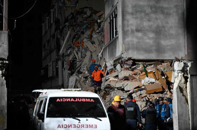 Rescue workers and volunteers search through the rubble of a collapsed building in Caracas on June 25, 2026, following a series of earthquakes. Desperate Venezuelans raced to find and rescue loved ones trapped alive beneath the rubble of collapsed buildings after two major earthquakes, measured at magnitudes 7.2 and 7.5, hit northern Venezuela killing at least 235 people and leaving more than 1,500 injured. (Photo by Maryorin Mendez / AFP)