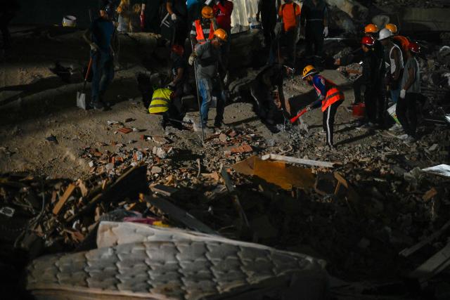 Rescue workers and volunteers search through the rubble of a collapsed building in Caracas on June 25, 2026, following a series of earthquakes. Desperate Venezuelans raced to find and rescue loved ones trapped alive beneath the rubble of collapsed buildings after two major earthquakes, measured at magnitudes 7.2 and 7.5, hit northern Venezuela killing at least 235 people and leaving more than 1,500 injured. (Photo by Maryorin Mendez / AFP)