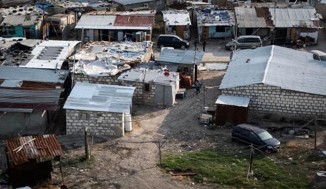 An aerial view shows the shacks of the Borgo Mezzanone makeshift camp hosting migrant workers near Foggia in the Apulia region, south of Italy, on June 23, 2026. During the peak summer season, it becomes home to approximately 3,000 people—mostly migrant farmworkers drawn to Puglia for the tomato harvest and high temperatures are making conditions even worse for migrant workers with a lack of basic services like water current, no sewage system, open air pile of trash. (Photo by Tiziana FABI / AFP)