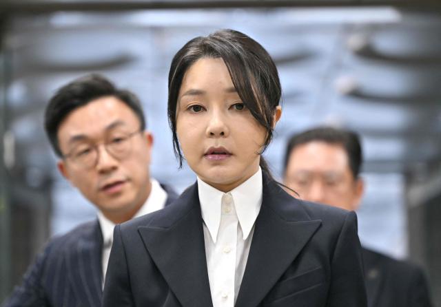 (FILES) South Korea's former first lady Kim Keon Hee (C), wife of impeached former president Yoon Suk Yeol, arrives at a court to attend a hearing to review her arrest warrant requested by special prosecutors at the Seoul Central District Court in Seoul on August 12, 2025. A South Korean court sentenced former first lady Kim Keon-hee, already serving time for a different graft case, to another seven years' imprisonment on June 26, 2026 in a jobs-for-gifts scandal. (Photo by JUNG YEON-JE / POOL / AFP)