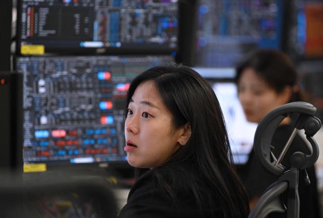 A currency dealer monitors exchange rates in a foreign exchange dealing room at the Hana Bank headquarters in Seoul on June 26, 2026. South Korean stocks collapsed more than eight percent on June 26, sparking a 20 minute halt in trading, amid a fresh rout in tech firms and following a sell-off on Wall Street. (Photo by Jung Yeon-je / AFP)