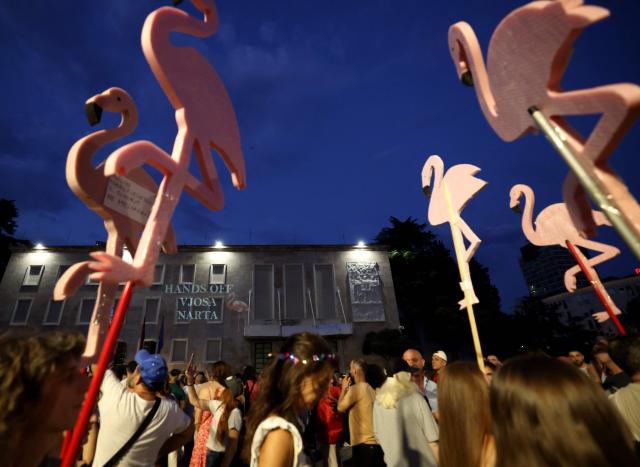 Protestors carry immitation flamingos as they gather in front of the Albanian Prime Minister's office to demonstrate against the construction, on the southern coast of Albania, of a luxury resort near a protected natural area, in Tirana, on June 25, 2026. Since late May 2026 protesters have thronged the streets every evening to oppose plans to build a luxury seaside resort at Zvernec, in a protected area, and on Sazan island, both in south-western Albania  valued at more than four billion euros and linked to Donald Trump's daughter Ivanka and her husband Jared Kushner. (Photo by Adnan Beci / AFP)