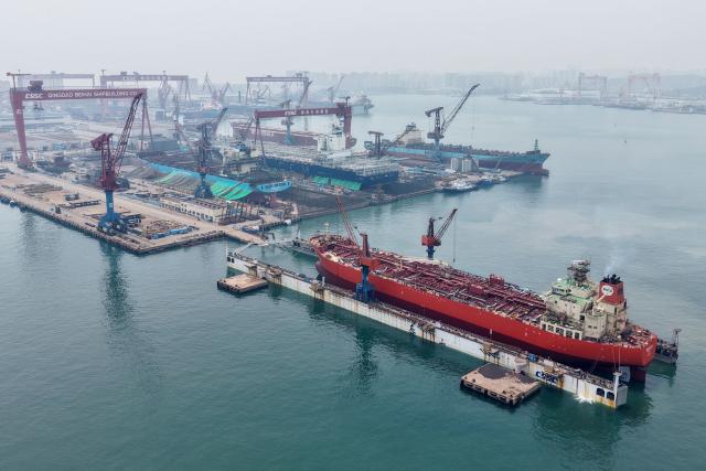 This aerial photo shows a new vessel leaving the dry dock for sea trials at the Qingdao Beihai Shipyard in Qingdao, China’s eastern Shandong province on June 25, 2026. (Photo by CN-STR / AFP) / China OUT