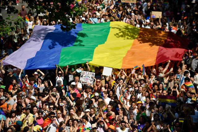 (FILES) A huge rainbow flag or gay pride flag is help up during the annual Pride Parade, in Paris on June 24, 2023. Paris police prefect asked on June 26, 2026, the organizers of "large-scale" events scheduled for this weekend in Paris—such as the Solidays festival, the Pride March, and the Charlety athletics meet—to cancel their events. The police prefecture justified this request by citing the "exceptional heatwave that has been ongoing since June 21," which is placing a strain on emergency services and healthcare facilities. In a statement, the prefecture warned that if the organizers in question do not "agree" to cancel these events, "the police prefect will ban them by official order." (Photo by JULIEN DE ROSA / AFP)