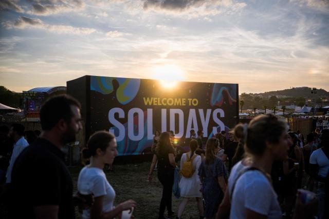 (FILES) Festivalgoers stroll at sunset during the 25th edition of the Solidays Music Festival at the Hippodrome de Longchamp race course, in Paris on June 23, 2023. Paris police prefect asked on June 26, 2026, the organizers of "large-scale" events scheduled for this weekend in Paris—such as the Solidays festival, the Pride March, and the Charlety athletics meet—to cancel their events. The police prefecture justified this request by citing the "exceptional heatwave that has been ongoing since June 21," which is placing a strain on emergency services and healthcare facilities. In a statement, the prefecture warned that if the organizers in question do not "agree" to cancel these events, "the police prefect will ban them by official order." (Photo by Julie SEBADELHA / AFP)