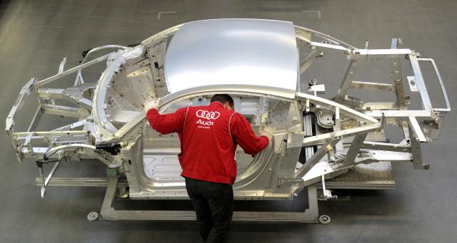 (FILES) An employee of German luxury car maker Audi works on an Audi R8 sportscar at an assembly line of the Audi plant in Neckarsulm, southwestern Germany, on February 15, 2012. According to a media report on June 26, 2026, the car manufacturer Volkswagen plans to cut up to 100,000 jobs. Four plants in Germany, including the Audi plant in Neckarsulm, are to be closed, the "Manager Magazin" reported, citing insiders. In addition, VW CEO Oliver Blume is reportedly planning to spin off the core Volkswagen brand into a new company. According to the report, the job cuts are planned worldwide. (Photo by THOMAS KIENZLE / AFP)