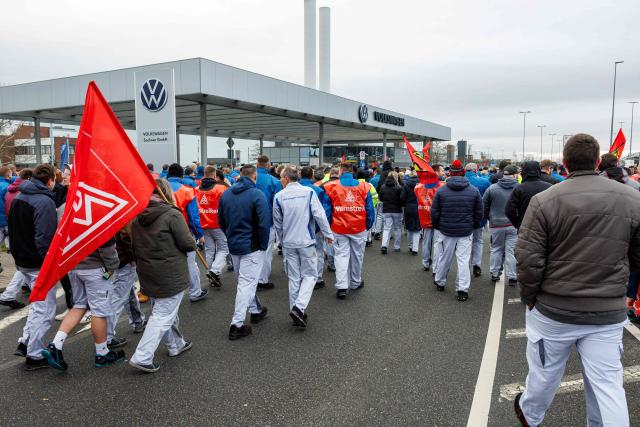 (FILES) Employees of German car maker Volkswagen (VW) demonstrate in front of the VW plant in Zwickau, eastern Germany, on December 2, 2024, as thousands of Volkswagen workers go on strike all over Germany in an escalating industrial dispute at the crisis-hit German auto giant with thousands of jobs at stake. Europe's largest carmaker Volkswagen is considering cutting tens of thousands more jobs worldwide and shuttering up to four plants in Germany, Manager Magazin reported on June 2026. Volkswagen is already planning to cut 50,000 jobs across its brands in Germany by 2030 as it is struggling with high costs, US tariffs and fierce Chinese competition in electric vehicles. Volkswagen would also close plants at Hanover, Zwickau and Emden after production runs of models currently made there end. (Photo by JENS SCHLUETER / AFP)