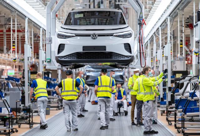 (FILES) Employees work at the assembly line for the Volkswagen (VW) ID 4 electric car of German carmaker Volkswagen, in the production site of Emden, northern Germany, on May 20, 2022. Europe's largest carmaker Volkswagen is considering cutting tens of thousands more jobs worldwide and shuttering up to four plants in Germany, Manager Magazin reported on June 2026. Volkswagen is already planning to cut 50,000 jobs across its brands in Germany by 2030 as it is struggling with high costs, US tariffs and fierce Chinese competition in electric vehicles. Volkswagen would also close plants at Hanover, Zwickau and Emden after production runs of models currently made there end. (Photo by DAVID HECKER / AFP)