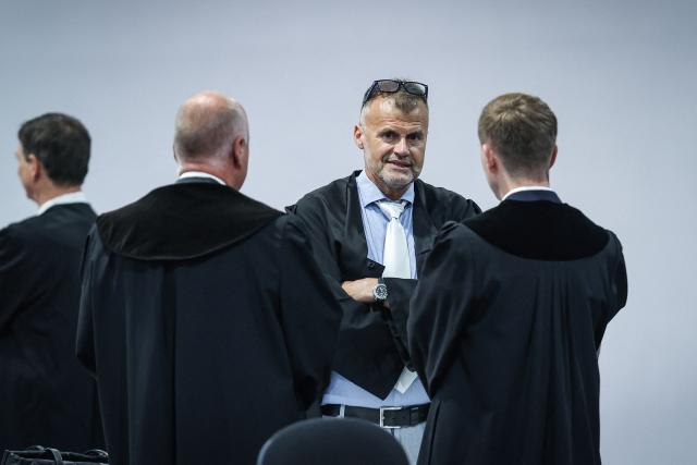 The pool lawyer for the joint plaintiffs, Carsten Schneider (2nd R) talks to Chief Public Prosecutor Matthias Boettcher (R) at the temporary courtroom in Magdeburg, eastern Germany, before the trial against Saudi Arabian defendant Taleb Jawad al-Abdulmohsen over the deadly Christmas market attack in December 2024. The court sentenced to life in jail the Saudi psychiatrist who drove an SUV through a crowded Christmas market in 2024, killing six people and injuring more than 300. (Photo by Ronny HARTMANN / AFP)