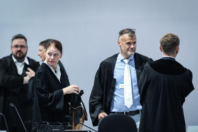 (L to R) The pool lawyers for the joint plaintiffs, Petra Kuellmei and Carsten Schneider talk to Chief Public Prosecutor Matthias Boettcher at the temporary courtroom in Magdeburg, eastern Germany, before the trial against Saudi Arabian defendant Taleb Jawad al-Abdulmohsen over the deadly Christmas market attack in December 2024. The court sentenced to life in jail the Saudi psychiatrist who drove an SUV through a crowded Christmas market in 2024, killing six people and injuring more than 300. (Photo by Ronny HARTMANN / AFP)