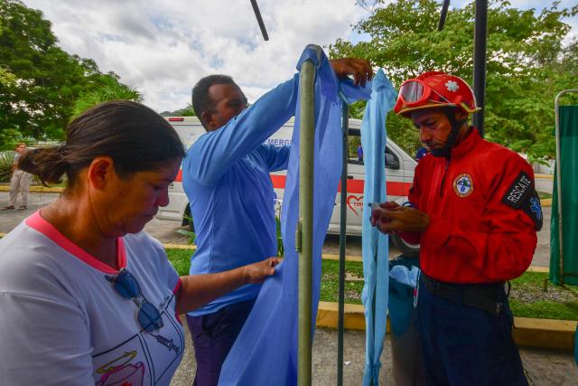 Rescue workers and paramedics set up a care center following twin earthquakes in Moron, Carabobo State on June 26, 2026. Rescuers used heavy machinery and their bare hands on June 26 in a race to save survivors of deadly twin earthquakes in Venezuela that killed at least 235 people, hurt thousands and flattened scores of buildings. (Photo by Orlando Obispo / AFP)