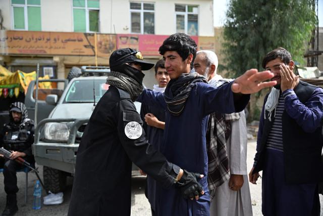 A Taliban security personnel frisks Afghans along a road, during the tenth day of the Islamic holy month of Muharram, in Kandahar on June 26, 2026. (Photo by Sanaullah SEIAM / AFP)