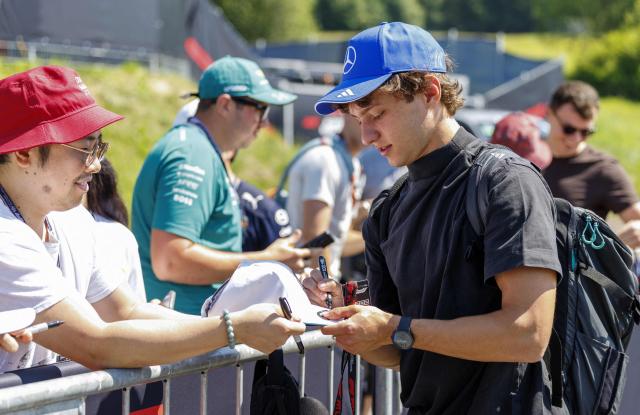 Mercedes' Italian driver Kimi Antonelli (R) signs autographs for fans as he arrives for the first practice session at the Red Bull Ring race track in Spielberg, Austria on June 26, 2026, ahead of the Formula One Austrian Grand Prix. (Photo by ERWIN SCHERIAU / APA / AFP) / Austria OUT